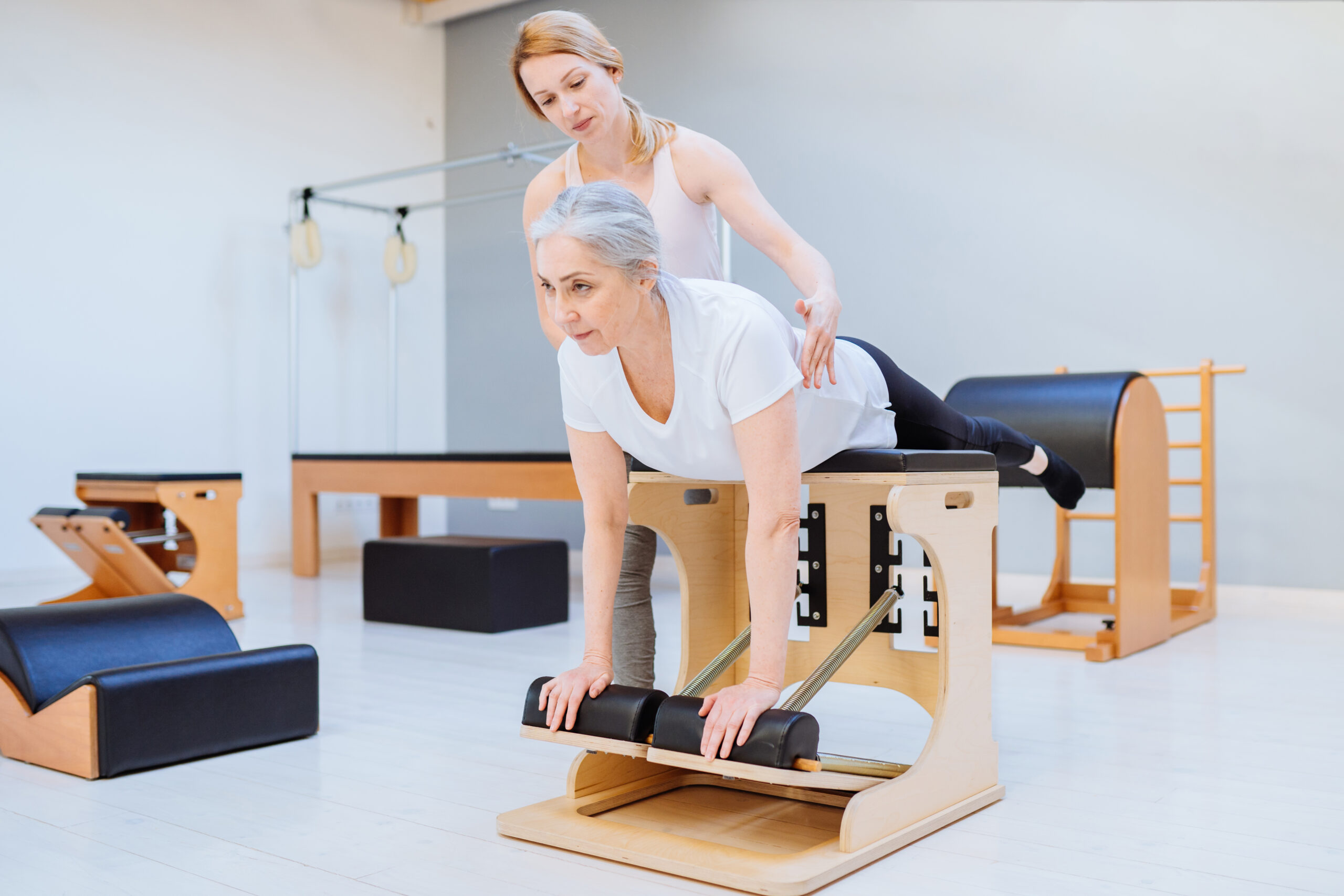 Elderly,Woman,Woman,Doing,Pilates,On,The,Pilates,Chair,,Supporting